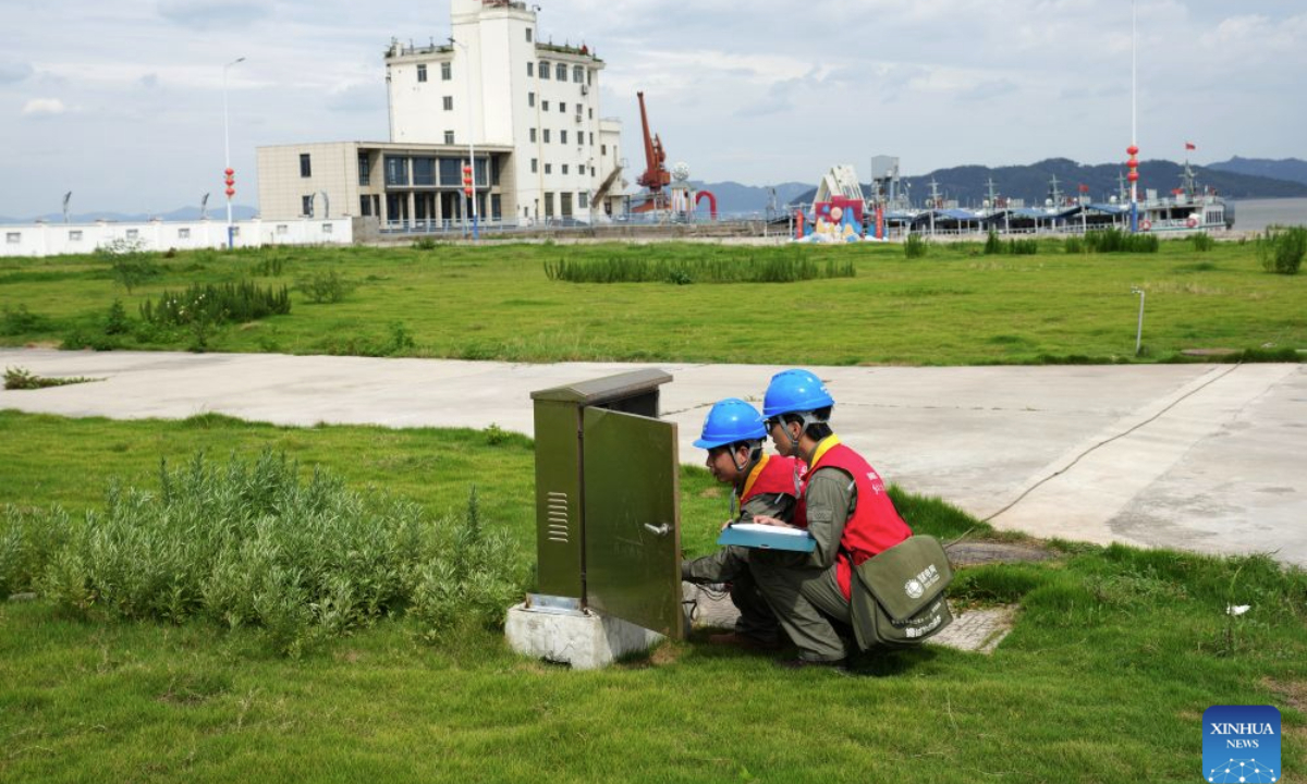 Power supply technicians inspect equipment at a fishing wharf in Yueqing City, east China's Zhejiang Province, Aug. 27, 2026. East China's Zhejiang Province raised its typhoon emergency response to Level I, the highest level, at 8 p.m. Thursday as Typhoon Saudel, the 18th typhoon of this year, is forecast to make landfall in the province. (Xinhua/Han Chuanhao)