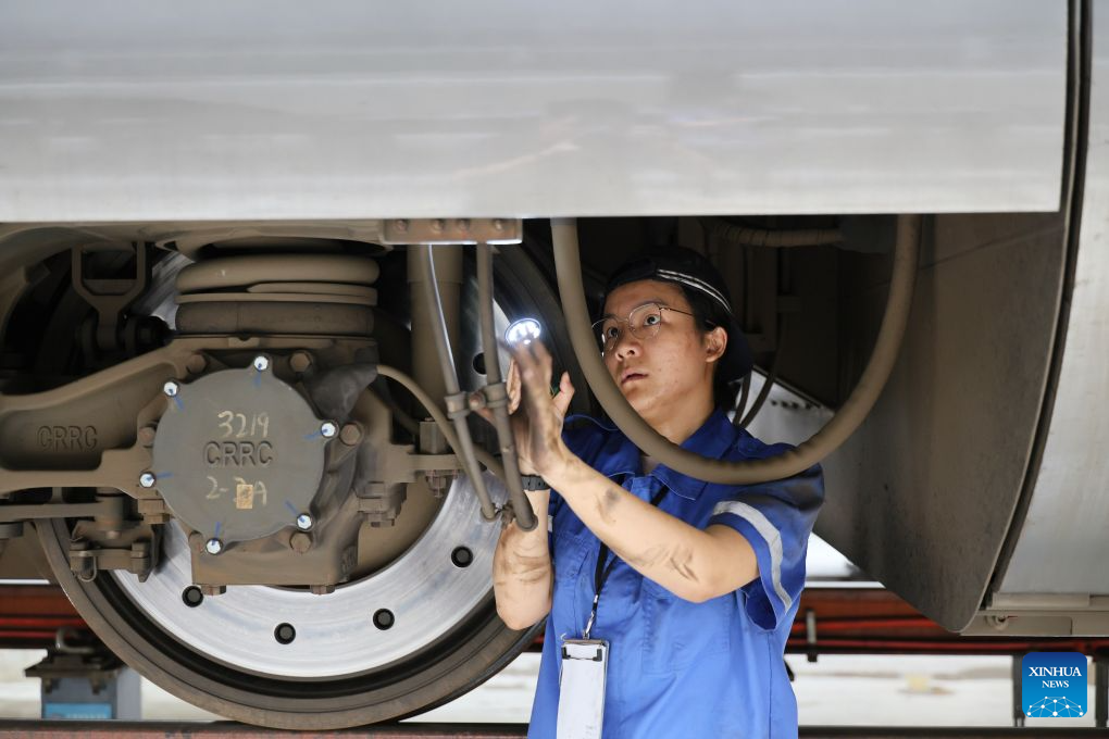 Li Weijia works at the maintenance base of an electric multiple unit (EMU) depot in Tianjin, north China, July 31, 2026.
During the summer travel rush, more than a hundred EMU mechanics work here in rotating shifts around the clock to ensure every train is thoroughly inspected and ready for service.
Among them is Li Weijia, a mechanic born in 1998. She carefully inspects electrical circuits and components, leaving no potential safety hazard unnoticed. Since joining the railway, Li has devoted herself to honing technical skills. In 2023, she claimed fifth in the technical skills competition organized by China Railway Beijing Bureau.
This year, Li tries her best to represent the China Railway Beijing Bureau at the China Railway Group's national technical skills competition. As the final selection draws near, she takes every maintenance task with exacting standards, striving for excellence in every detail. (Xinhua/Li Ran)