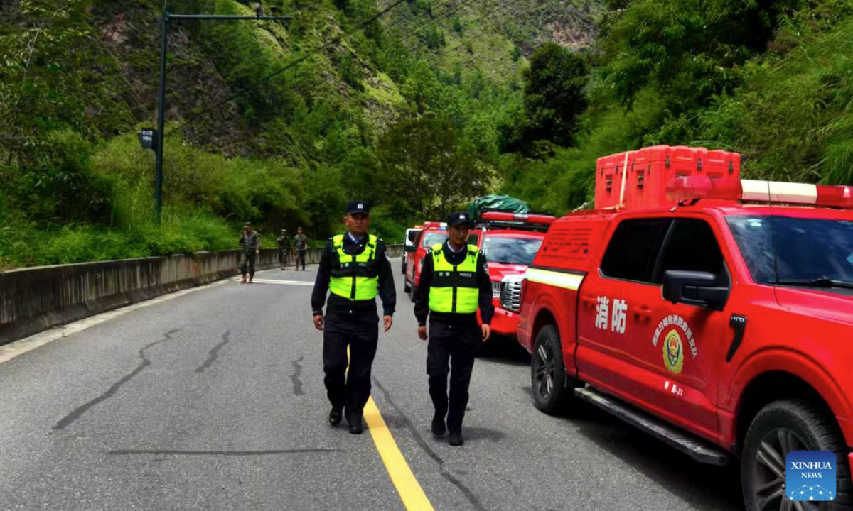 Police officers work on a highway leading to the Gyirong Port in Xigaze, southwest China's Xizang Autonomous Region, on Aug. 27, 2026. A total of 164 traffic police officers have been deployed to the mudslide-stricken areas in Gyirong to ensure the orderly movement of emergency response and supply vehicles. (Xinhua)