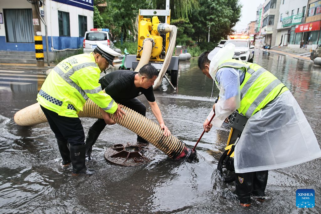 Staff members drain flood water from a water-logged road in Weishi County of Kaifeng, central China's Henan Province, Aug. 11, 2026. Torrential rains and flooding caused by Typhoon Dolphin, the 13th typhoon of the year, have swept vast regions in eastern and central China. Local authorities are exerting all efforts to eradicate potential risks and put people's life back to normal. (Photo by Li Xinyi/Xinhua)