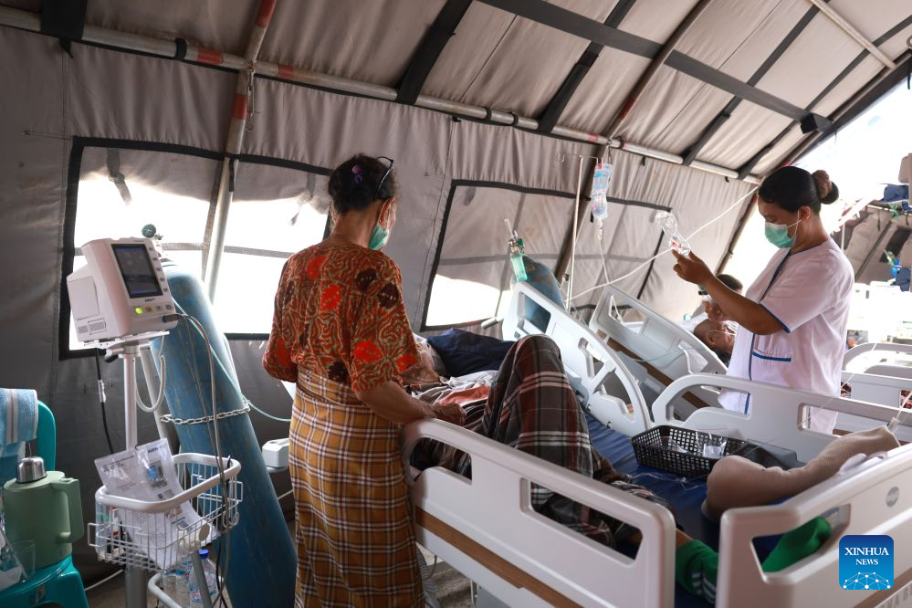 A health worker treats a patient at an emergency tent outside Komodo Regional Hospital, East Nusa Tenggara Province, Indonesia, Aug. 17, 2026. The death toll from a 7.7-magnitude earthquake that struck Indonesia's East Nusa Tenggara (NTT) province has risen to 68, the National Disaster Management Agency (BNPB) said Monday. (Indonesia's Ministry of Health/Handout via Xinhua)
