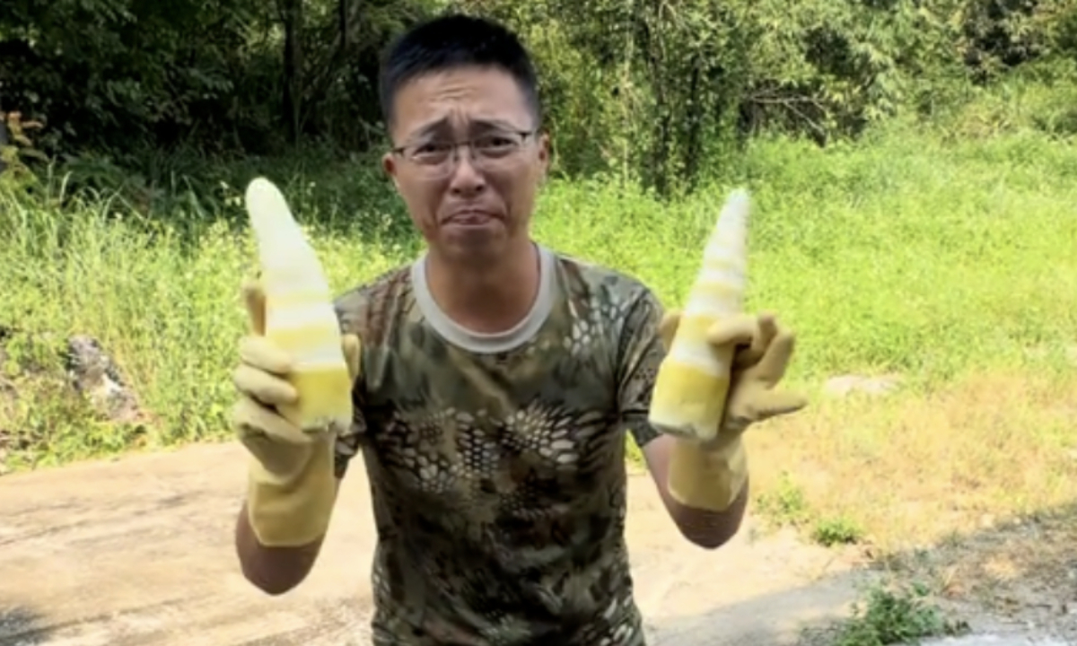Chinese vlogger Yulie Qige holds two bamboo shoots allegedly fumigated illegally with sulfur. Photo: Screenshot from Tide News