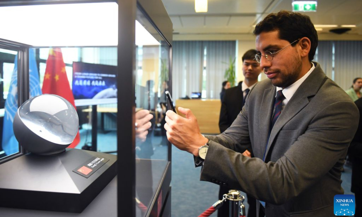 A man takes photo of a lunar sample collected from the far side of the Moon by China's Chang'e-6 mission, in Vienna, Austria, Sept. 14, 2026. China on Monday formally presented a lunar sample collected from the far side of the Moon by its Chang'e-6 mission to the United Nations (UN) in Vienna, where the sample will be permanently exhibited. (Xinhua/He Canling)