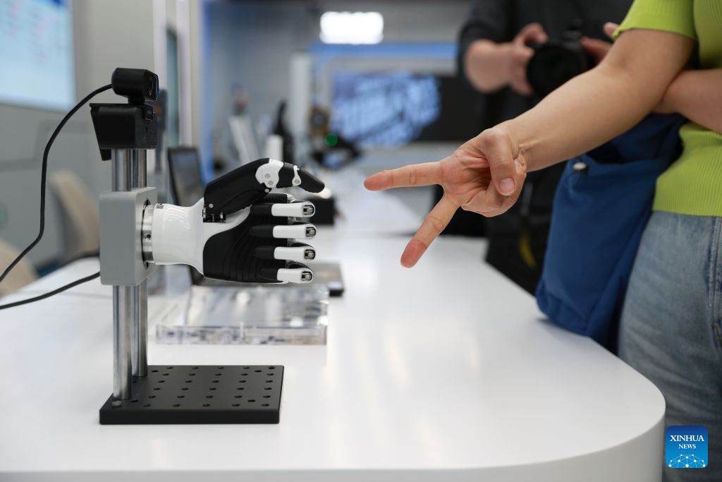 A dexterous hand plays rock-paper-scissors with a visitor at the Beijing Innovation Center of Humanoid Robotics in Beijing, capital of China, July 1, 2026. The Beijing Economic-Technological Development Area, also known as Beijing E-Town, has managed to cultivate and strengthen a modern system of emerging and forward-looking industries. (Photo by Ma Zihan/Xinhua)