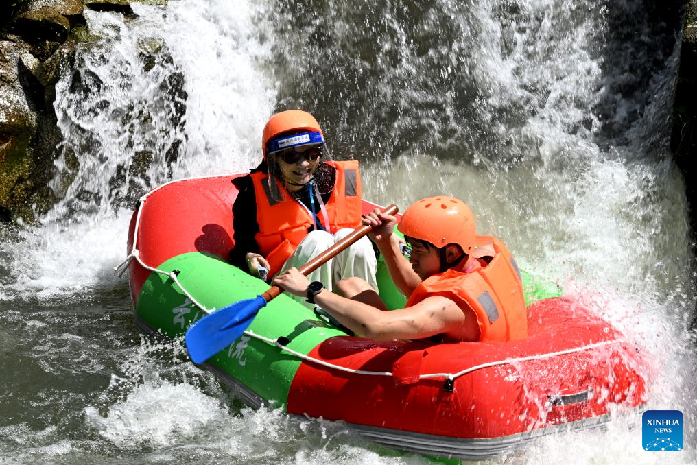 Tourists enjoy rafting at a scenic area in Tongcheng County, central China's Hubei Province, Aug. 1, 2026. (Photo by Liu Jianping/Xinhua)