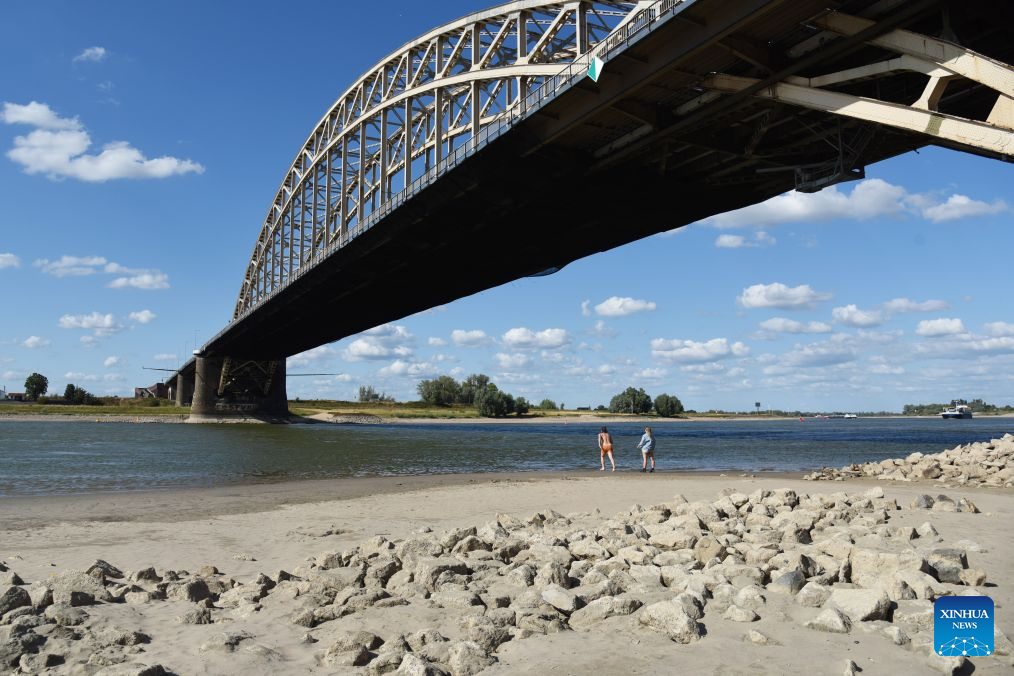 People enjoy themselves on the exposed bank of the Waal River in Nijmegen, Gelderland Province, the Netherlands, Aug. 6, 2026. (Xinhua/Shao Haijun)