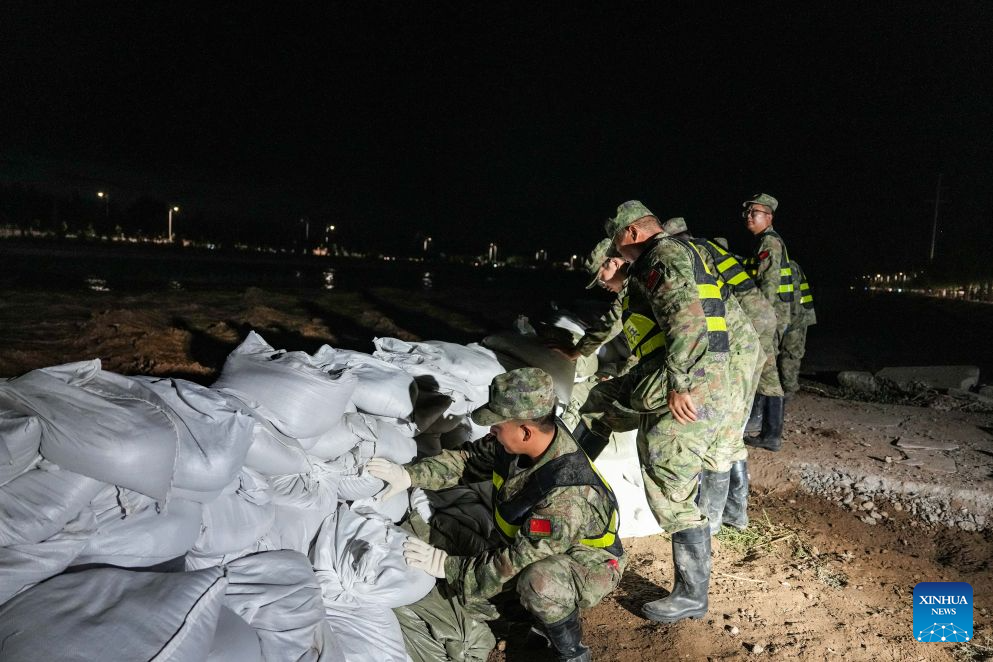 Militiamen stack sandbags to fortify the embankment along the Danghe River in Dunhuang, northwest China's Gansu Province, July 29, 2026. The water level of the Danghe River, which runs through Dunhuang City in northwest China's Gansu Province, rose rapidly following days of heavy rainfall and increased inflows from upstream. Local personnel in Dunhuang quickly mobilized for flood control and relief operations. (Xinhua/Lang Bingbing)
