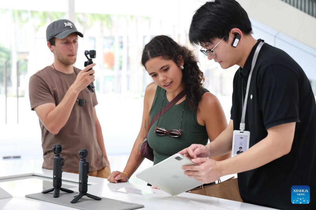 This photo taken on June 24, 2026 shows foreign tourists buying handheld camera equipment at a flagship shop of DJI in Shenzhen, south China's Guangdong Province. With the deep application of the achievements of emerging industries, many inbound foreign tourists choose science and technology tour as the theme of their journey in the Chinese cities.
In Shenzhen, foreign tourists are attracted by AI applications and technology scenarios in daily life, such as AI glasses, smart robots and unmanned delivery service. (Xinhua/Liang Xu)