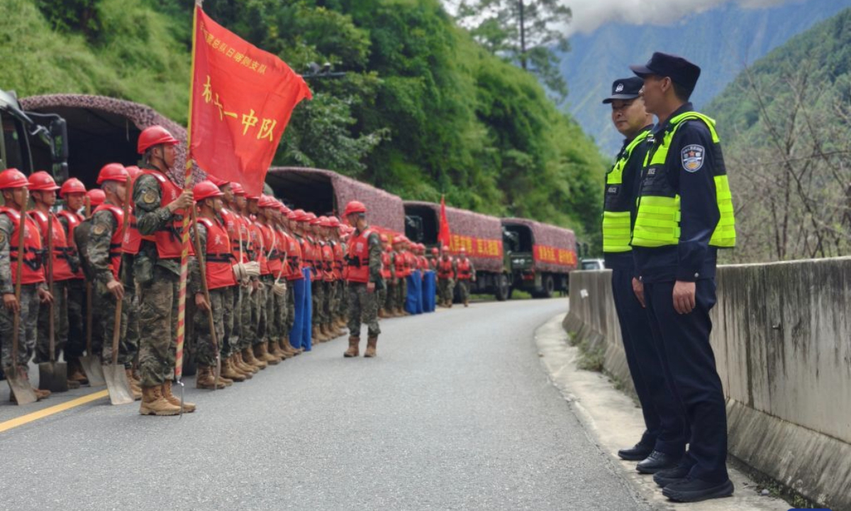 Police officers work on a highway leading to the Gyirong Port in Xigaze, southwest China's Xizang Autonomous Region, on Aug. 27, 2026. A total of 164 traffic police officers have been deployed to the mudslide-stricken areas in Gyirong to ensure the orderly movement of emergency response and supply vehicles. (Xinhua)