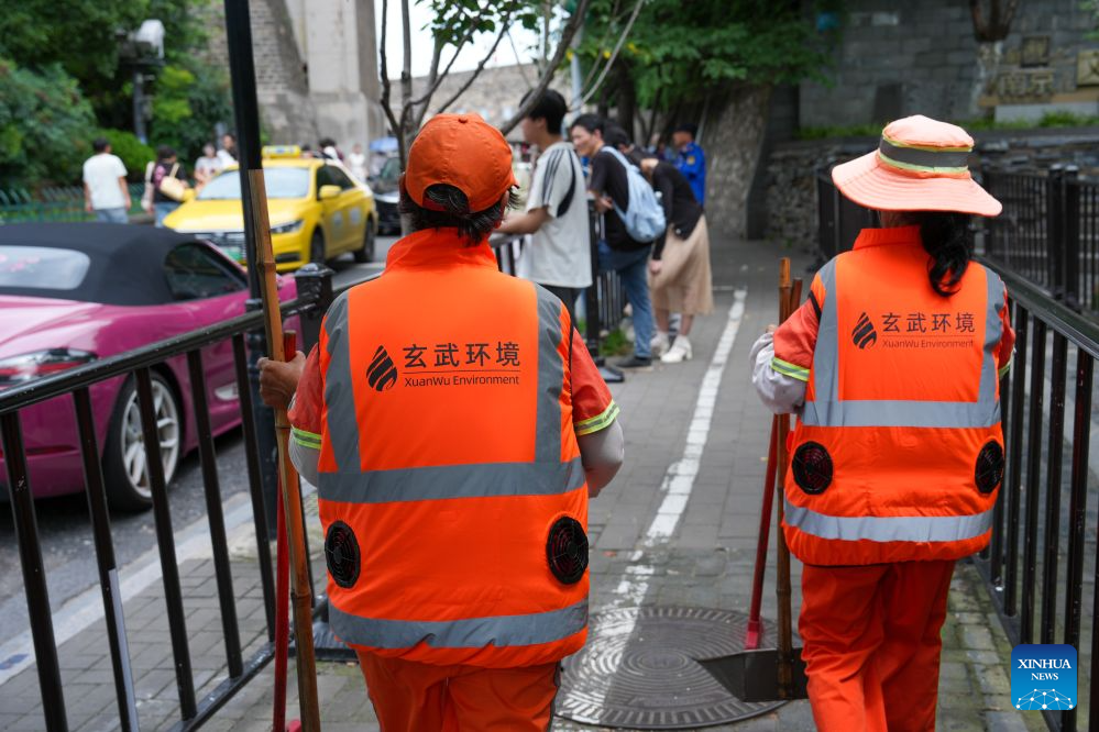 Sanitation workers in cooling vests walk on the street in Nanjing, east China's Jiangsu Province, July 28, 2026. Recently, in response to the high summer temperatures, sanitation workers in Xuanwu District of Nanjing City have been equipped with cooling vests. The vests are fitted with miniature fans on both sides of the waist, providing inward airflow. (Xinhua/Li Bo)