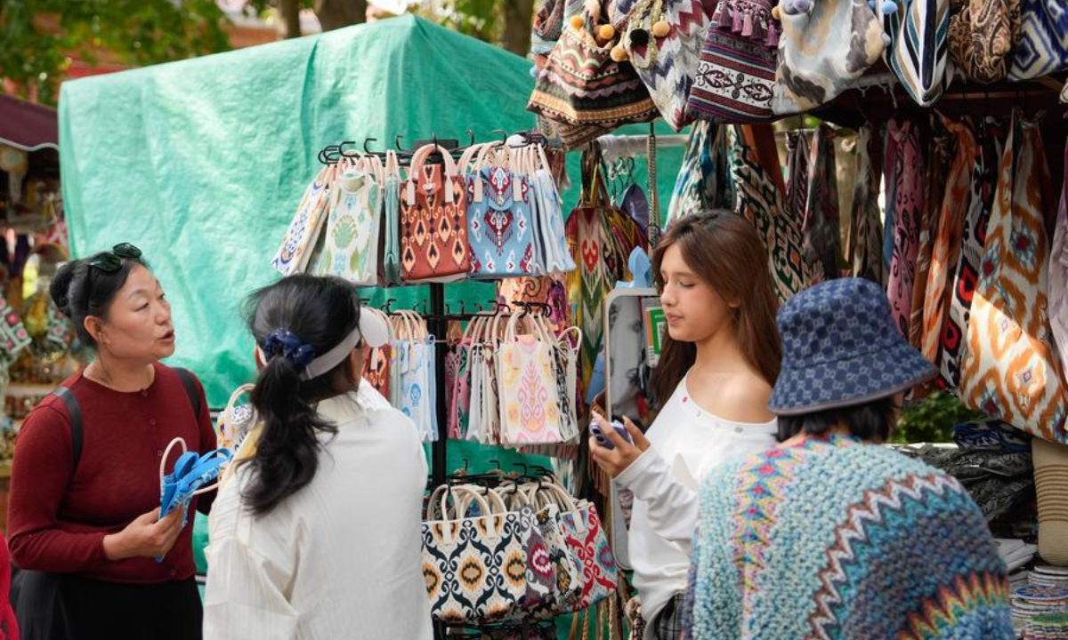 Tourists buy souvenirs in Liuxing block of Yining, Ili Kazak Autonomous Prefecture, northwest China's Xinjiang Uygur Autonomous Region, Sept. 8, 2025. Liuxing block in Yining is named for its hexagonal alleys where people of multiple ethnic groups live together. (Xinhua/Zhang Haobo)