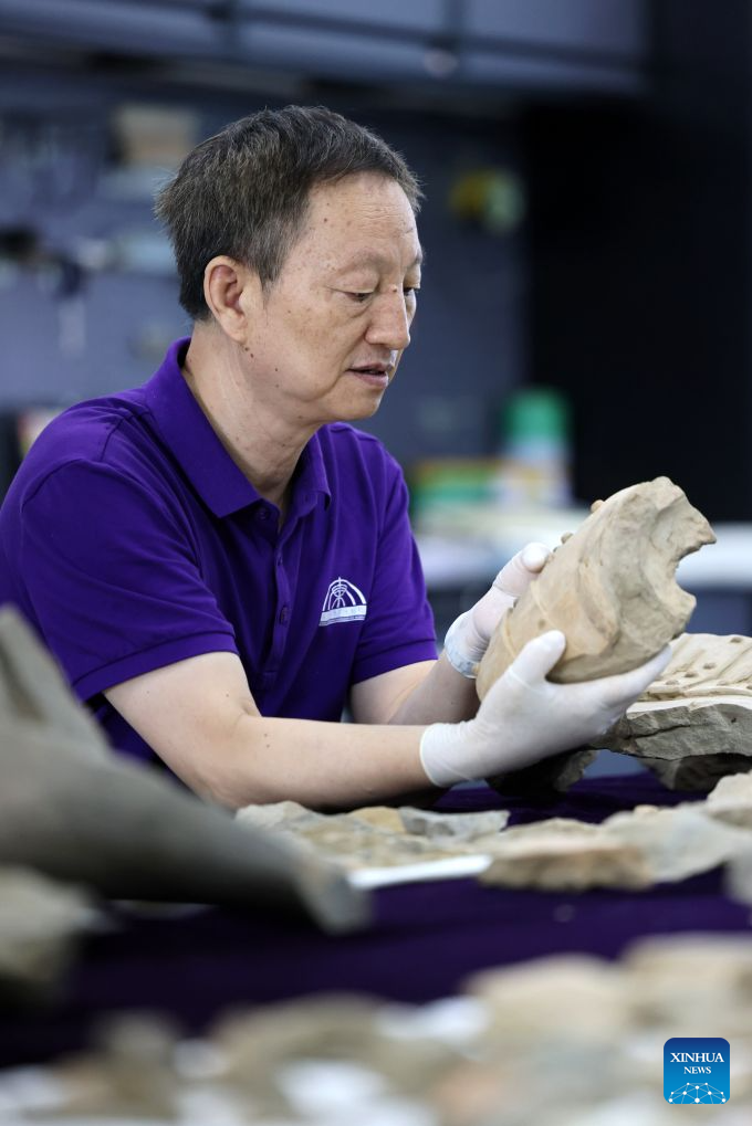 A restoration specialist checks a piece of excavated terracotta warrior fragment at the on-site conservation lab of the Pit No.1 of the Emperor Qinshihuang's Mausoleum Site Museum in Xi'an, northwest China's Shaanxi Province, Sept. 3, 2026. (Xinhua/Li Yibo)