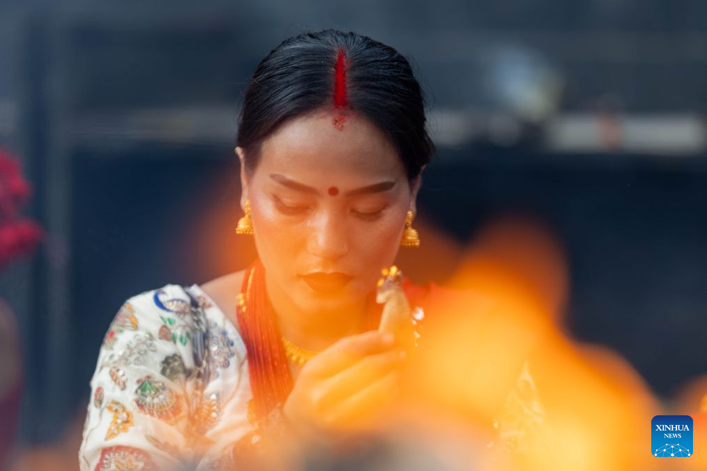 A woman offers prayers at the Pashupatinath Temple during the Teej Festival in Kathmandu, Nepal, Sept. 14, 2026. Hindu women observe the festival by fasting, praying and celebrating, seeking marital well-being and ideal partners. (Photo by Sulav Shrestha/Xinhua)