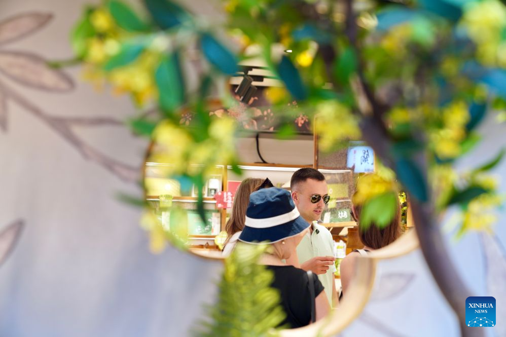 Members of a joint China-Russia media delegation taste tea as they visit Pingjiang Road, a block of historical and cultural interest, in Suzhou, east China's Jiangsu Province, Aug. 23, 2026. The delegation visited Suzhou from Aug. 22 to 23, experiencing the charm of China's Jiangnan culture. (Xinhua/Lu Jinbo)