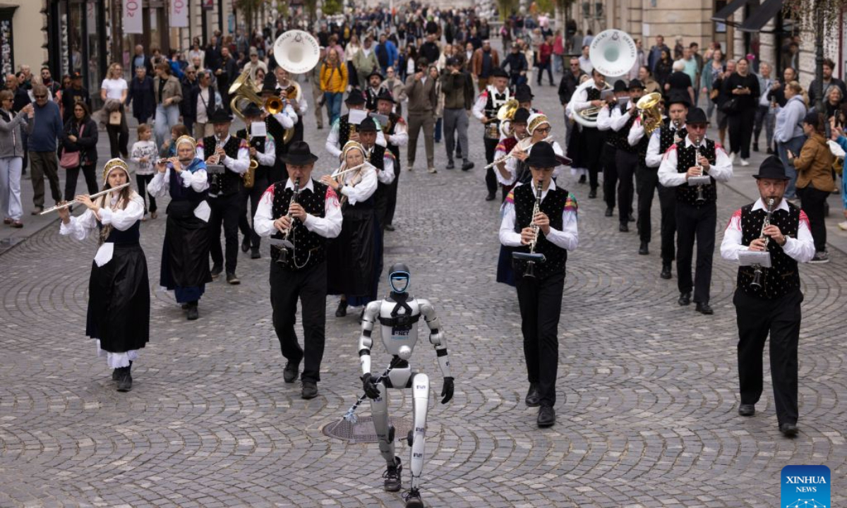 A Unitree G1 humanoid robot conducts the Ljubljana Wind Orchestra during the parade of the Ljubljana Wind Orchestra in Ljubljana, Slovenia, Oct. 11, 2026. (Photo by Zeljko Stevanic/Xinhua)
