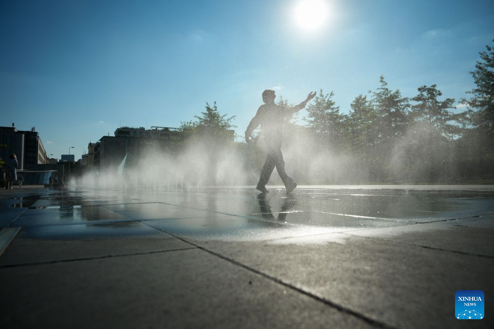 A man walks in a splash pad to cool off in Warsaw, Poland, July 16, 2026. (Photo by Jaap Arriens/Xinhua)