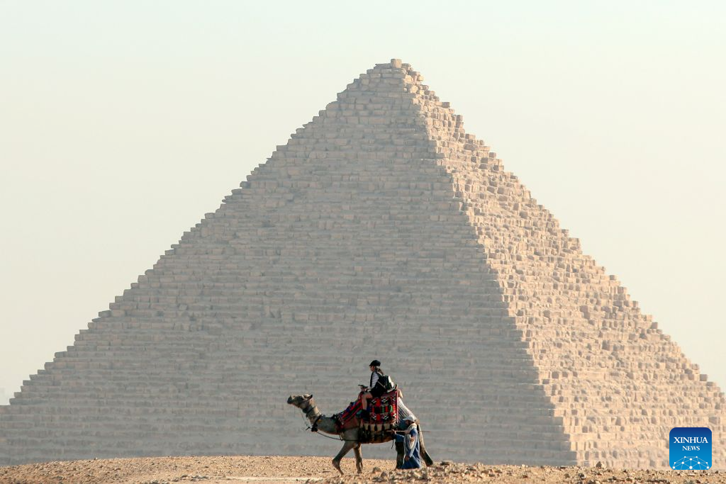 A tourist rides camels at the Pyramids scenic spot in Giza, Egypt, Aug. 16, 2026. (Xinhua/Ahmed Gomaa)