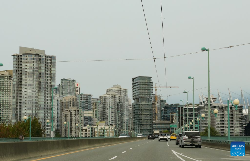 Vehicles run on a road under smoky sky in Vancouver, British Columbia, Canada, Aug. 4, 2026. Amid extreme heatwaves and record-breaking drought, wildfires have broken out in many parts of Canada, reducing air quality and visibility in the affected areas. (Photo by Liang Sen/Xinhua)