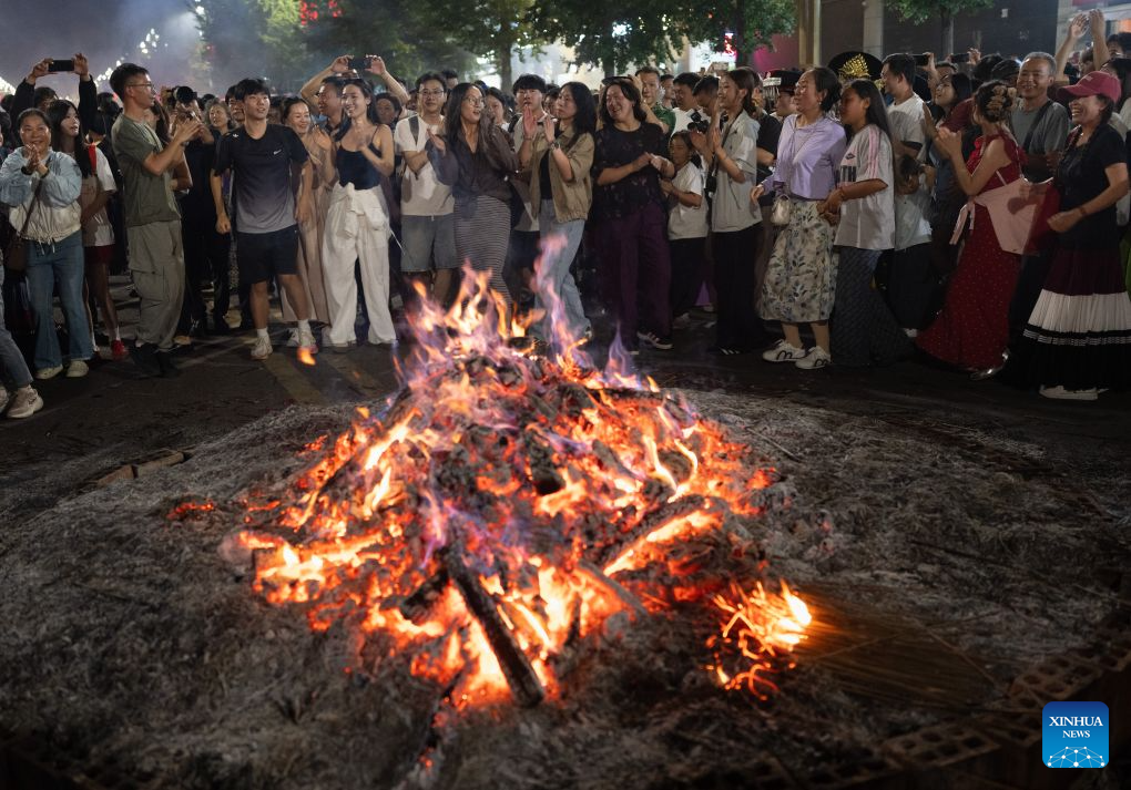 People of the Yi ethnic group celebrate the torch carnival night with visitors in Yuexi County of southwest China's Sichuan Province, Aug. 2, 2026. From Aug. 2 to 4, a torch festival tourism season was held in Yuexi County of southwest China's Sichuan. The event featured torch carnival nights, folk cultural competitions, dancing and singing contests. The torch festival is a traditional celebration of the Yi ethnic group, usually held around the 24th day of the sixth month on the Chinese lunar calendar each year. (Xinhua/Jiang Hongjing)