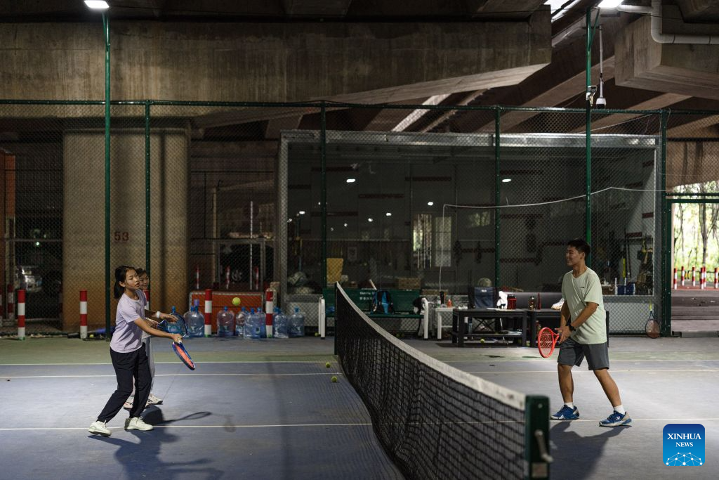 People play tennis beneath a super major bridge in Kunming, southwest China's Yunnan Province, Aug. 11, 2026. In recent years, Kunming has transformed some vacant areas beneath urban bridges and flyovers into public spaces for greenery, leisure, recreation and physical exercises, making the city more livable for residents. (Xinhua/Wang Guansen)