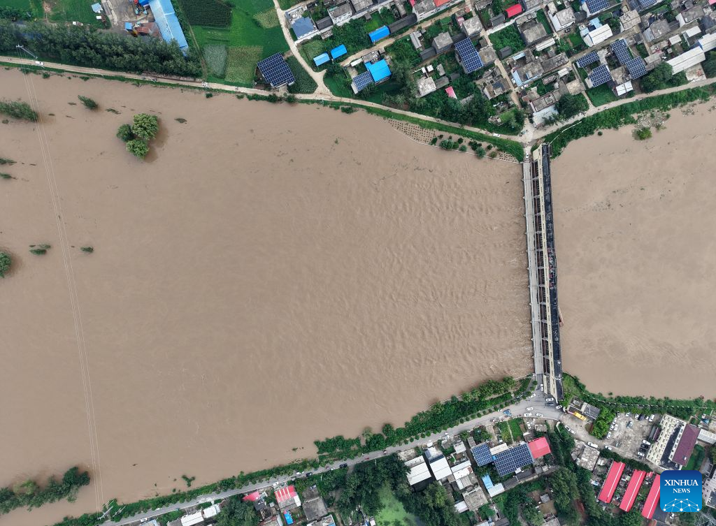An aerial drone photo taken on Aug. 13, 2026 shows a flood discharge scene at the Nihewa flood storage and detention area in Wuyang County of Luohe City, central China's Henan Province. Affected by Typhoon Dolphin, the 13th typhoon of the year, the Shaying River has recorded a flow rate exceeding 3,000 cubic meters per second in its Luohe section, while the water level continues to rise. In accordance with relevant contingency plans, Henan Province activated the Nihewa flood storage and detention area on Thursday. (Xinhua/Hao Yuan)