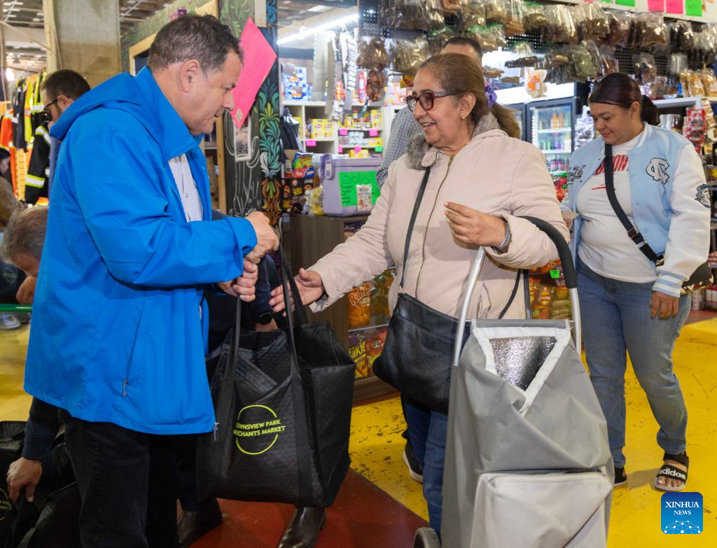 A woman (R, front) picks up a free turkey at a farmers' market during the Thanksgiving Turkey Drive in Toronto, Canada, on Oct. 11, 2026. The annual event took place here on Sunday, providing 300 free turkeys for residents in need ahead of Canada's Thanksgiving Day, which falls on the second Monday of October each year. (Photo by Zou Zheng/Xinhua)