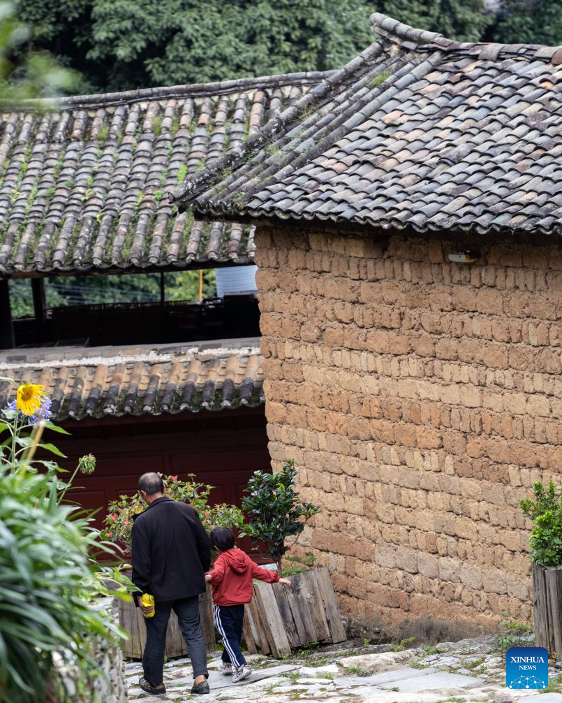 This photo taken on July 26, 2026 shows local residents walking in Lushi ancient town in Fengqing County of Lincang City in southwest China's Yunnan Province. Lushi ancient town in the northeast of Fengqing County lies between the Lancang River and Heihui River. Due to its special geographical location, Lushi was once an important trading hub on the ancient Tea Horse Road, a trade route dating back to the Tang Dynasty (618-907). The town has formed an unique culture that is influenced by merchants coming and going as well as multi-ethnic cohabitation. (Photo by Lan Hongguang/Xinhua)