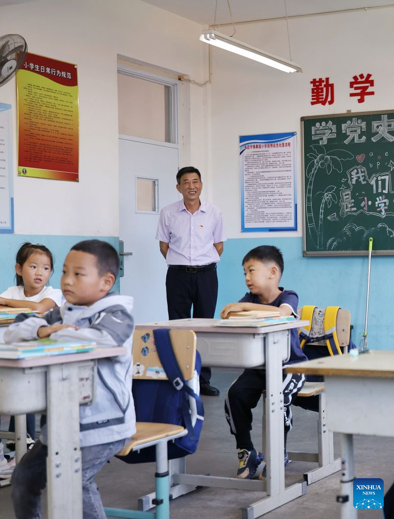 Zheng Baoguo checks on first-graders during class in Luozhuangzi Town of Jizhou District in Tianjin, north China, on Sept. 1, 2026. (Xinhua/Li Ran)