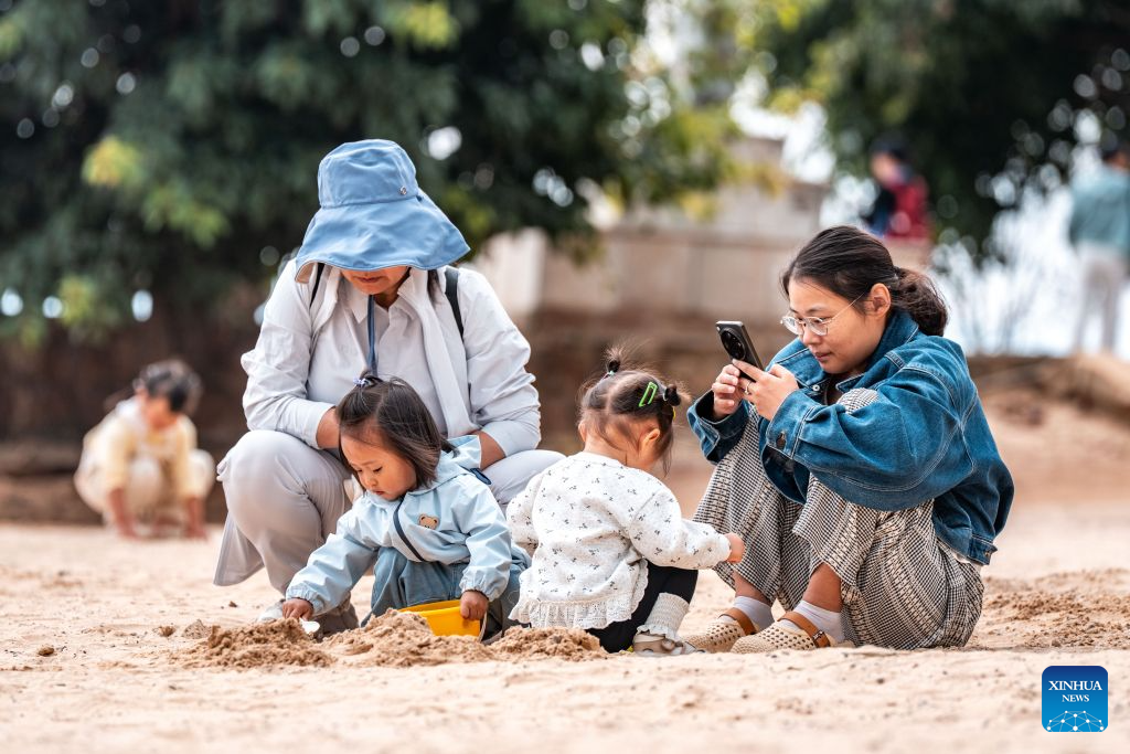 Tourists enjoy their leisure time at a scenic area on the west bank of Fuxian Lake in Yuxi City, southwest China's Yunnan Province, Sept. 14, 2026. In recent years, local authorities have stepped up efforts to protect ecological environment of Fuxian Lake and developed more lakeside activities, combining the natural scenery with local fishing culture to create more consumption experiences. (Xinhua/Hu Chao)