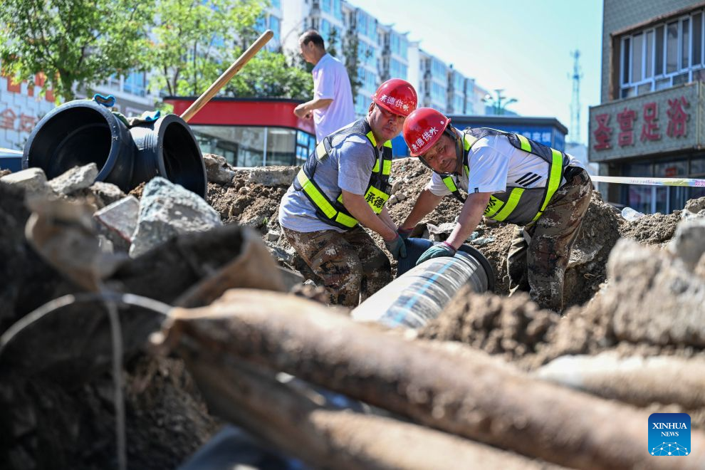 Staff members install a temporary water supply pipeline in Kuancheng Township, Kuancheng Manchu Autonomous County of Chengde, north China's Hebei Province, July 14, 2026. Recently, heavy rainfall lashed four townships and nine villages in Kuancheng Manchu Autonomous County. Local authorities have launched relief efforts to restore infrastructure and normal life. (Photo by Wang Liqun/Xinhua)