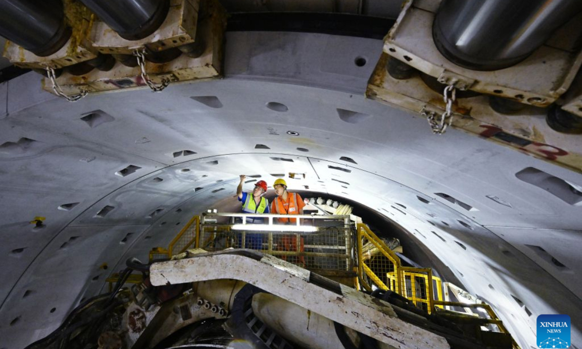 Constructors make a safety inspection at the construction site of Qingdao Jiaozhou Bay Second Tunnel in Qingdao, east China's Shandong Province, Oct. 2, 2026. China's longest undersea highway tunnel completed all shield-driven excavation work on Friday as a shield machine reached its designated position at a depth of 105 meters beneath the sea surface in Jiaozhou Bay, eastern China's Shandong Province, according to China Railway Construction Corporation Limited. The Qingdao Jiaozhou Bay Second Tunnel will connect Qingdao's main urban area with the Qingdao West Coast New Area. The latter is a national-level new area. The 17.48-km project includes a 14.37-km main tunnel section, featuring two main tunnels and a middle service tunnel, with three lanes in each direction and a design speed of 80 km per hour. (Xinhua/Li Ziheng)