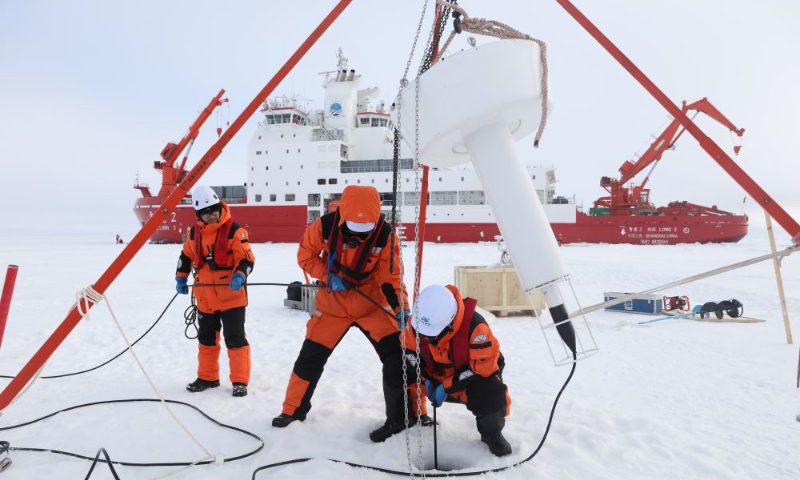 Members of the Xuelong 2 crew of China's 16th Arctic expedition deploy an ice-based buoy on August 9, 2026. Photo: Wen Jinghua/Xinhua