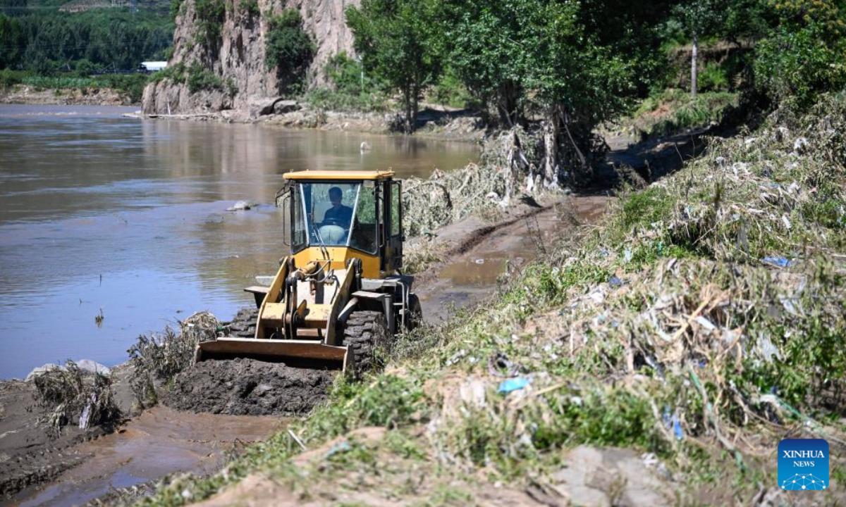 A worker clears mud after rainfall in Sanjia Village, Kuancheng Manchu Autonomous County of Chengde, north China's Hebei Province, July 15, 2026. Recently, heavy rainfall lashed four townships and nine villages in Kuancheng Manchu Autonomous County. Local authorities have launched relief efforts to restore infrastructure and normal life. (Photo by Wang Liqun/Xinhua)