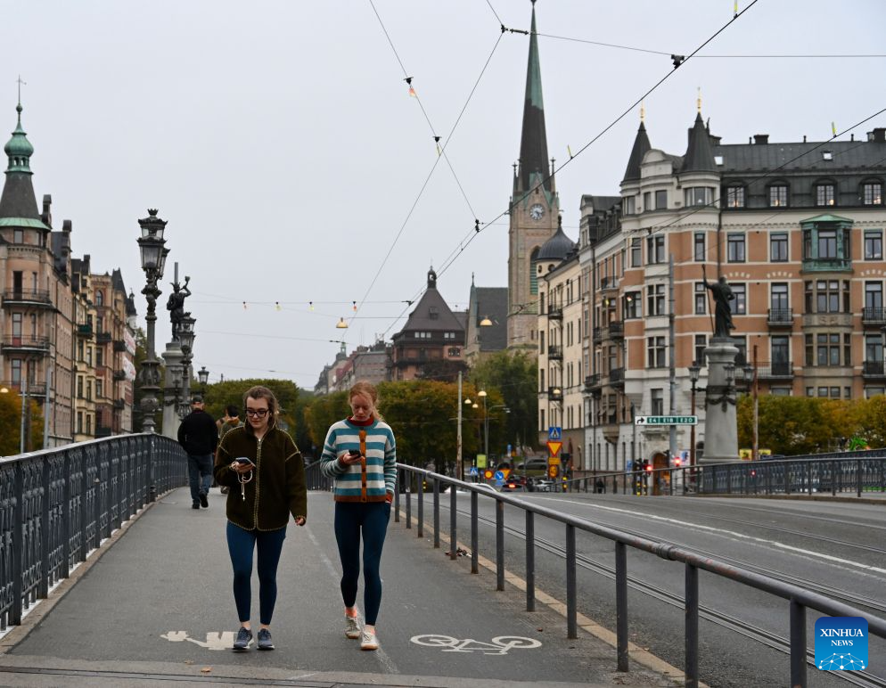 People walk past a bridge in Stockholm, Sweden, Oct. 5, 2026. (Xinhua/Lyu You)