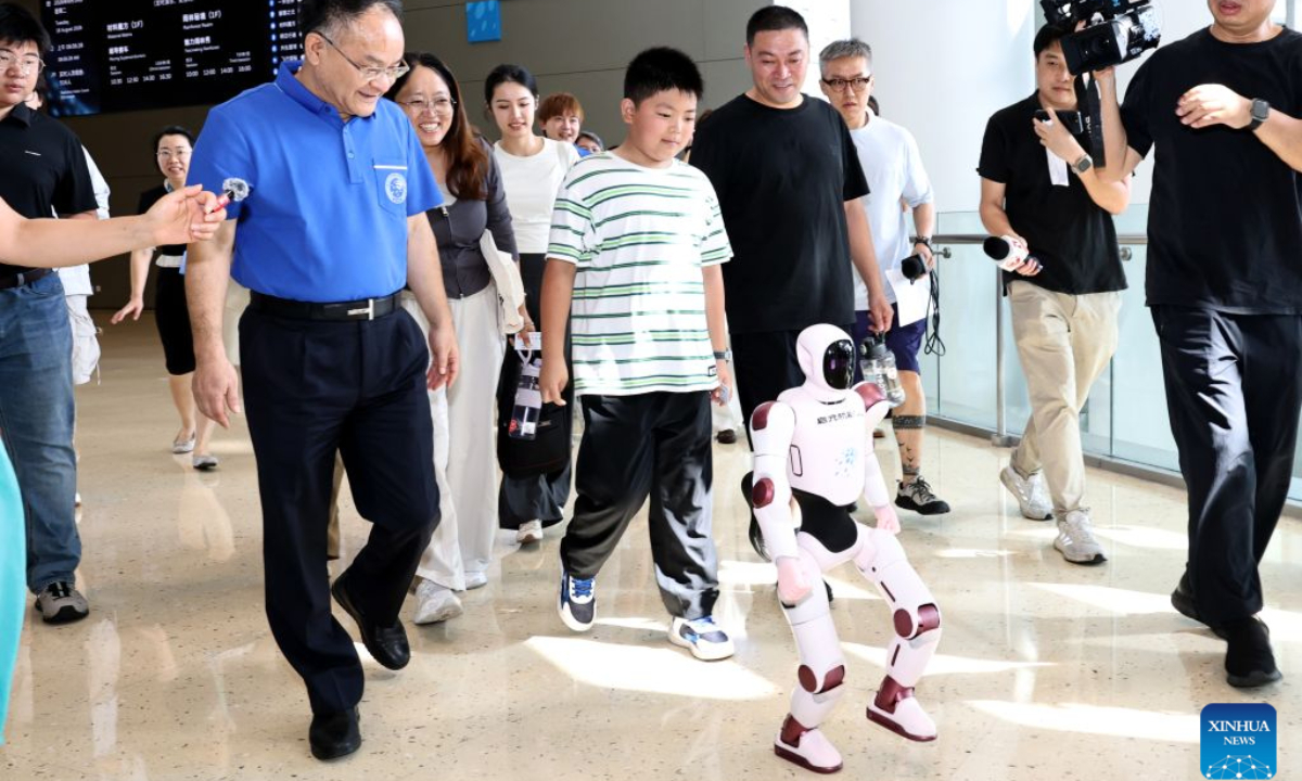 Zhang Zhiheng (C, front), the one hundred millionth visitor of Shanghai Science and Technology Museum, walks with his parents and museum director Ni Minjing (1st L, front) for a themed event at the museum in Shanghai, east China, Aug. 18, 2026. The number of visits to Shanghai Science and Technology Museum exceeded 100 million on Tuesday since its opening in 2001. It is a comprehensive science and technology museum complex that integrates a science and technology museum, a natural history museum, and a planetarium. (Xinhua/Fang Zhe)