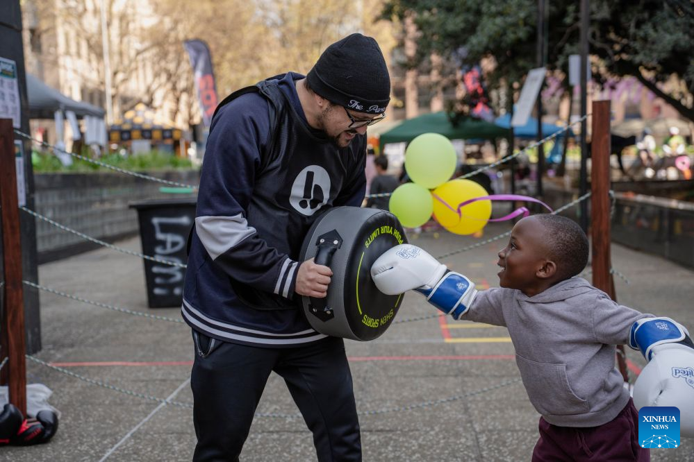 People enjoy boxing on a street during a car-free event in Johannesburg, South Africa, Aug. 9, 2026. During the event, some streets in Johannesburg were turned into car-free zones from 10 a.m. to 5 p.m., with motor vehicles banned. (Photo by Ihsaan Haffejee/Xinhua)