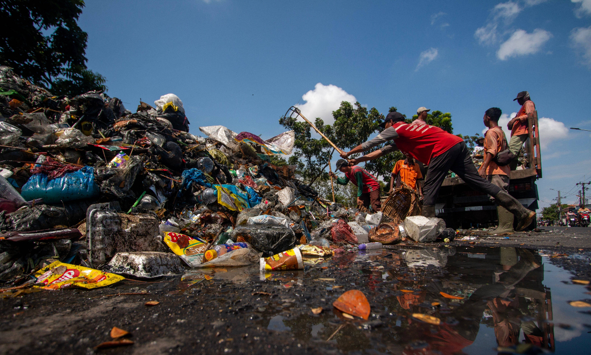 Environmental activists clean plastic waste from Kali Tebu River in Surabaya, Indonesia, on June 20, 2026. Photo: VCG