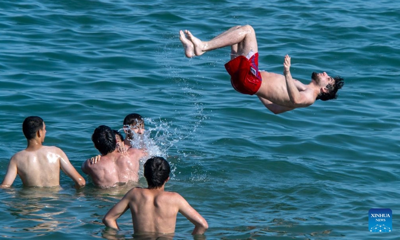 People have fun in the Caspian Sea in Baku, Azerbaijan, June 20, 2026. The temperature in Baku hit 33 degrees Celsius in the afternoon on June 20. Shikhov Beach in Baku attracted numerous locals and tourists for swimming and leisure. (Xinhua/Chen Junfeng)