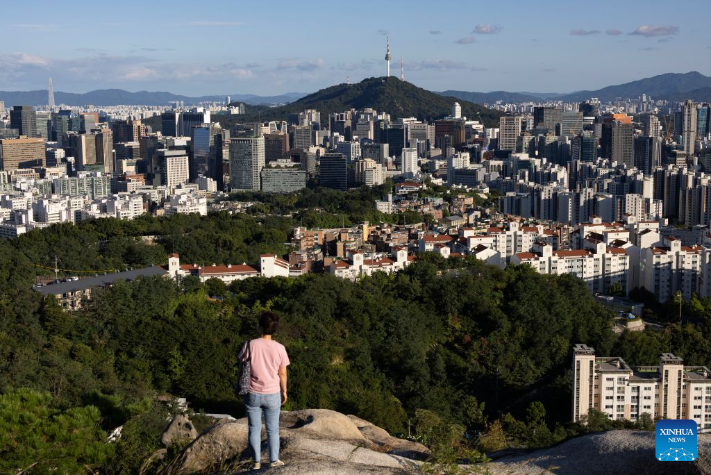 A woman enjoys the downtown scenery in Seoul, South Korea, Sept. 6, 2026. (Photo by Jun Hyosang/Xinhua)