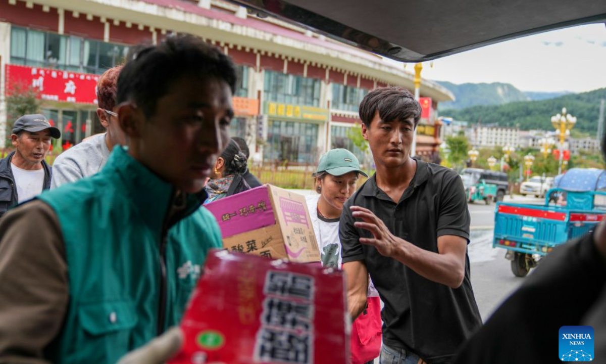 People unload instant noodles from a vehicle in Gyirong Town of Gyirong County, Xigaze City, southwest China's Xizang Autonomous Region, Aug. 27, 2026. Six vehicles loaded with relief supplies, including instant noodles, rice, flour, mineral water and other daily necessities, arrived in Gyirong Town on Thursday afternoon. (Xinhua/Jigme Dorje)