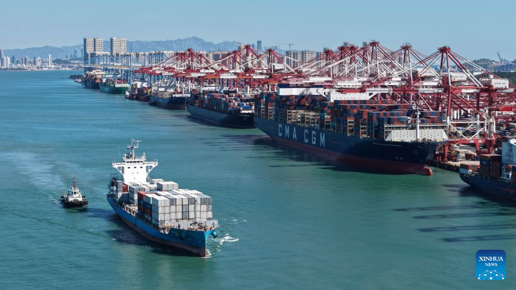 A drone photo taken on Oct. 8, 2026 shows cargo ships docking at Qingdao Port in Qingdao, east China's Shandong Province. As an international shipping hub in Northeast Asia, Qingdao Port has been expanding its shipping network, adding 16 foreign trade routes so far this year. The port now operates nearly 240 foreign trade routes, connecting over 700 ports in over 180 countries and regions. (Xinhua/Li Ziheng)