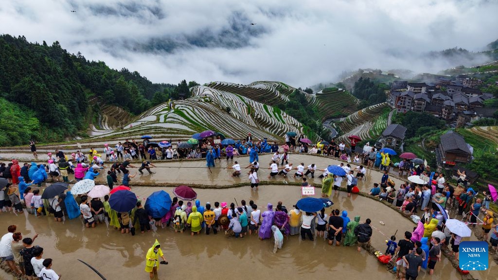 An aerial drone photo taken on June 20, 2026 shows people watching a tug-of-war game held amid terraced fields in Ping'an Village of Longji Township, Longsheng County, south China's Guangxi Zhuang Autonomous Region. (Photo: Xinhua)