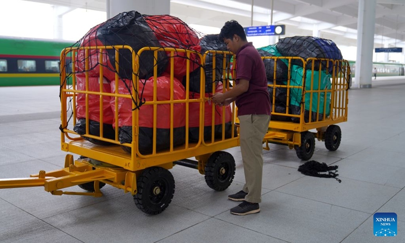 A worker stands next to carts loaded with baggage and parcels at the platform of Vientiane Station of the China-Laos Railway, in Vientiane, Laos, June 22, 2026. (Photo: Xinhua)