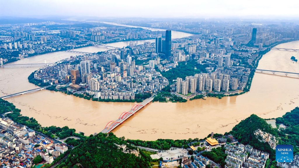An aerial drone photo taken on June 22, 2026 shows the flood peak passing through the Liujiang River in Liuzhou, south China's Guangxi Zhuang Autonomous Region. Due to heavy rainfall, the Liuzhou hydrological station on the Liujiang River recorded the first flood peak of 2026 on Monday, with the highest water level reaching 85.64 meters, exceeding the alert line by 3.14 meters while flooding some riverfront roads. (Photo: Xinhua)