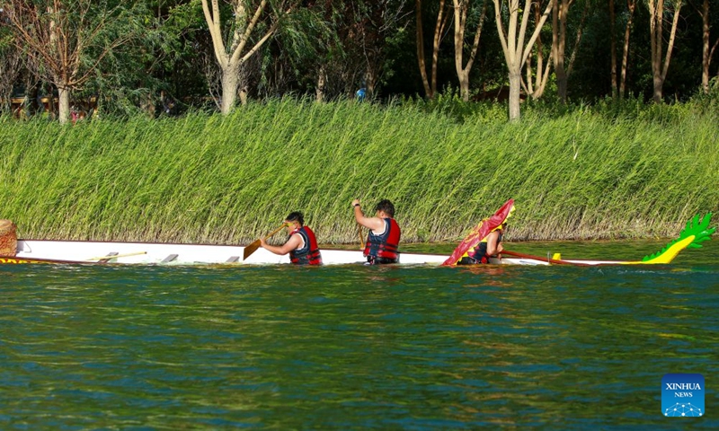 Anwar Kurban (R) and his teammates compete during the 2026 dragon boat race on Hongyan River in Korla City, northwest China's Xinjiang Uygur Autonomous Region, June 20, 2026. The 2026 dragon boat race was held on the Hongyan River in Korla on Saturday. During the final sprint, the boat of Halayugong Town team capsized suddenly when it hit strong currents, and all team members fell into the water. Captain Anwar Kurban stayed calm and quickly gathered all his teammates. (Photo: Xinhua)