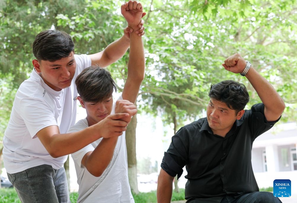 Anwar Kurban (L) instructs his teammates on dragon boat paddling movements in his spare time in Korla City, northwest China's Xinjiang Uygur Autonomous Region, June 15, 2026. (Photo: Xinhua)