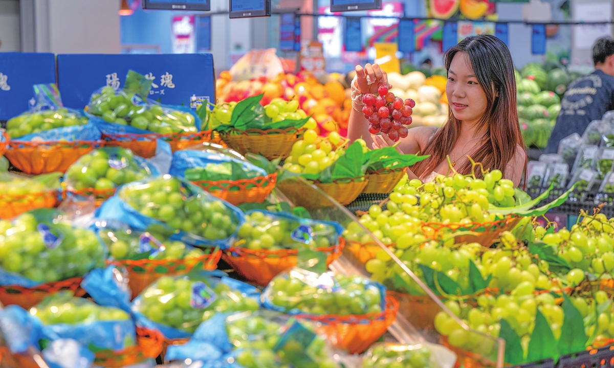 A customer chooses fruits at a supermarket in Wuzhou, South China's Guangxi Zhuang Autonomous Region, on June 23, 2026. Official data showed that China's consumer market remained generally stable in May, with the core consumer price index, excluding food and energy prices, rising 1.1 percent year-on-year, while food prices fell 1.7 percent. Photo: VCG