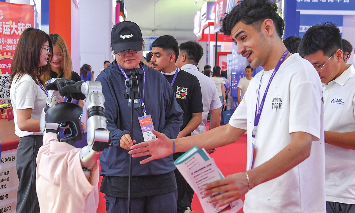 Foreign exhibitors interact with a robot at the 2026 Zhejiang Yiwu Electronic Commerce Expo in Yiwu, East China's Zhejiang Province, on June 23, 2026. The event brings together companies from the US, Russia, South Korea, Southeast Asia, South America, the Middle East and other regions, along with more than 1,200 source manufacturers from more than 20 industrial clusters across China. Photo: VCG