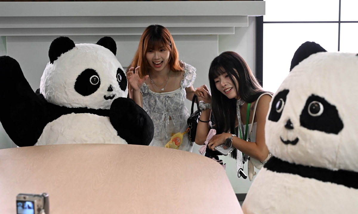 Participants take photos with giant panda plush toys at a cross-Straits youth science summer camp at the Panda World conservation center in Fuzhou, East China's Fujian Province, on June 24, 2026. The participants from both sides of the Taiwan Straits are on a five-day tour featuring science, technology and cultural exploration. Photo: VCG