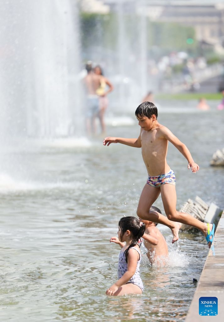 A boy jumps into a fountain in front of the Eiffel Tower in Paris, France, June 23, 2026. The Eiffel Tower in Paris closed early on Tuesday due to high temperature. (Photo: Xinhua)